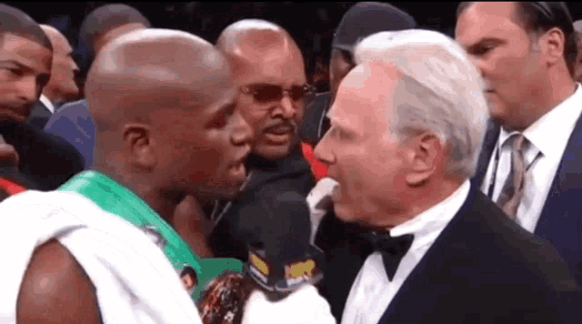 a man in a tuxedo is talking to a boxer