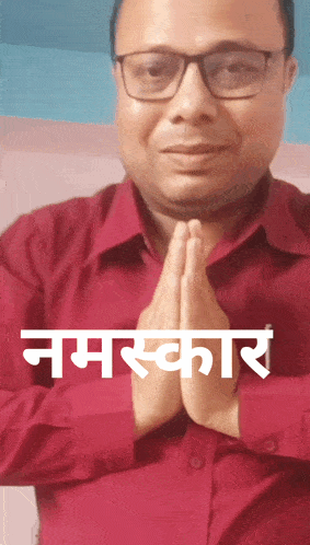 a man wearing glasses and a red shirt prays with his hands folded in front of him