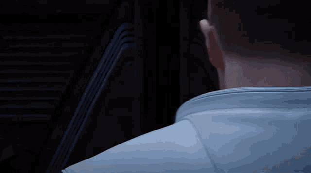 a close up of a man 's back with a white jacket on
