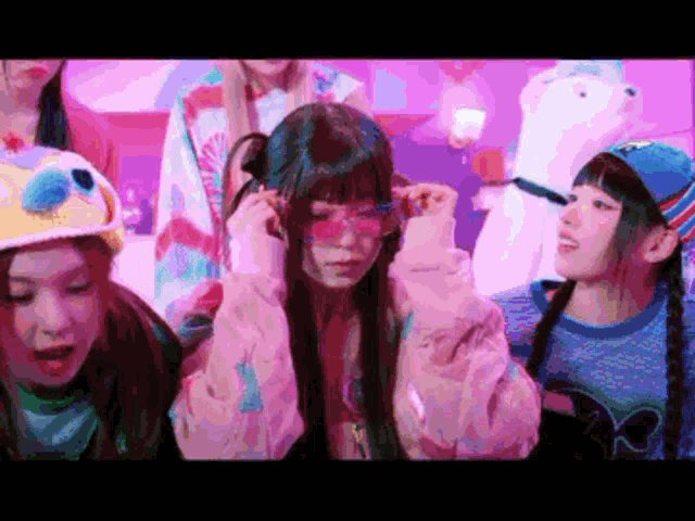 a group of girls wearing sunglasses and hats are standing in a room .