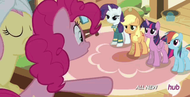 a group of ponies standing around a table with the words all new hub on the bottom right