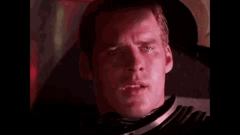 a man is sitting in a chair with his eyes closed and his mouth open .