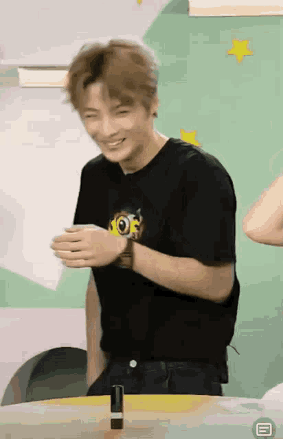 a man wearing a black shirt with the word joe on it is smiling