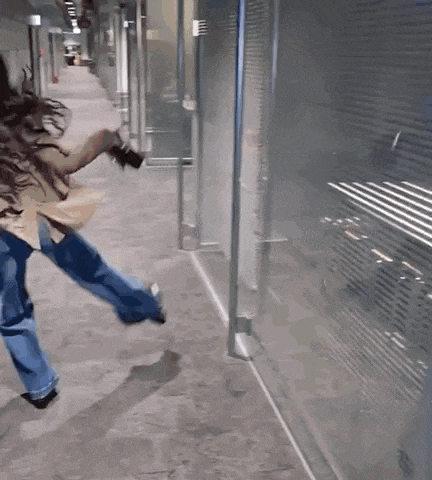 a person is running down a hallway with a camera in their hand .