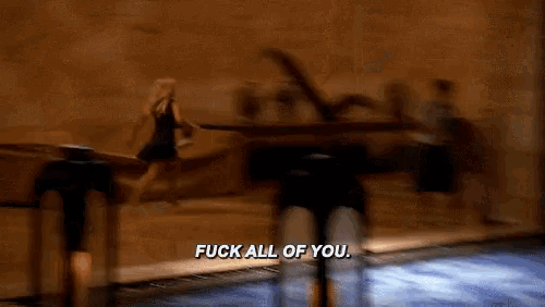 a blurry picture of a person saying " fuck all of you " in front of a piano .