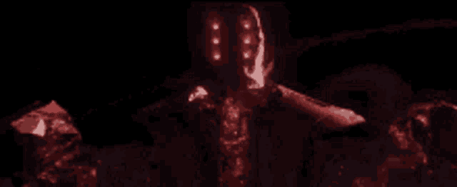 a person is standing in the dark with a red light coming out of their eyes .