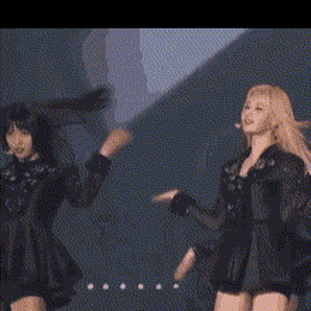 two women are standing next to each other on a stage .
