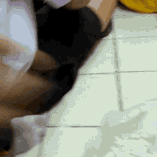 a person is laying on the floor with their legs crossed and a yellow bag in the background .