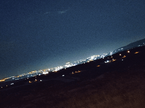 a blurry picture of a city at night with a dark sky
