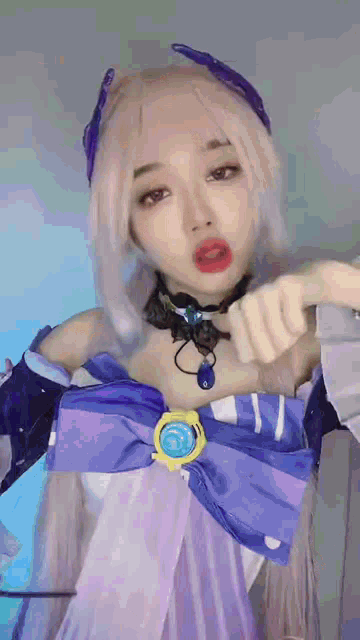 a woman in a purple and blue costume is pointing at something .