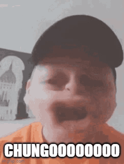 a young boy wearing a hat is making a funny face and says chungo000000 .