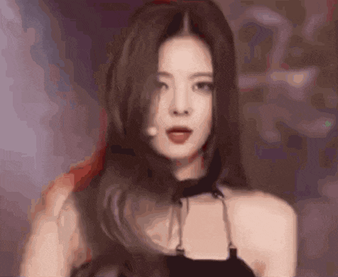 a close up of a woman 's face with long hair and a choker around her neck .