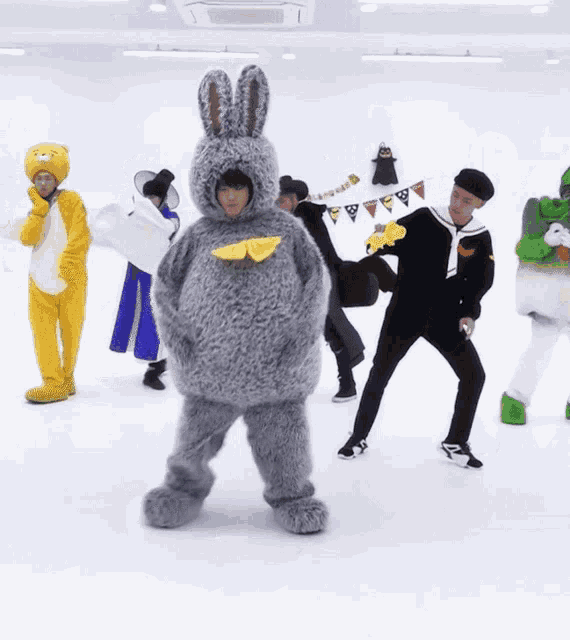 a group of people dressed in costumes are dancing in a room