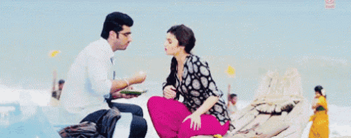 a man and a woman are sitting on a boat on the beach .