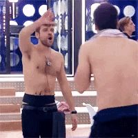 two shirtless men are standing next to each other in front of a mirror .