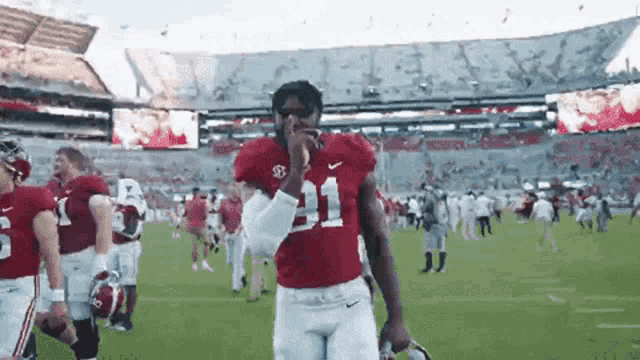 a football player wearing a number 11 jersey stands on the field
