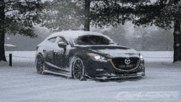 a mazda car is covered in snow and the word corksport is on the bottom right