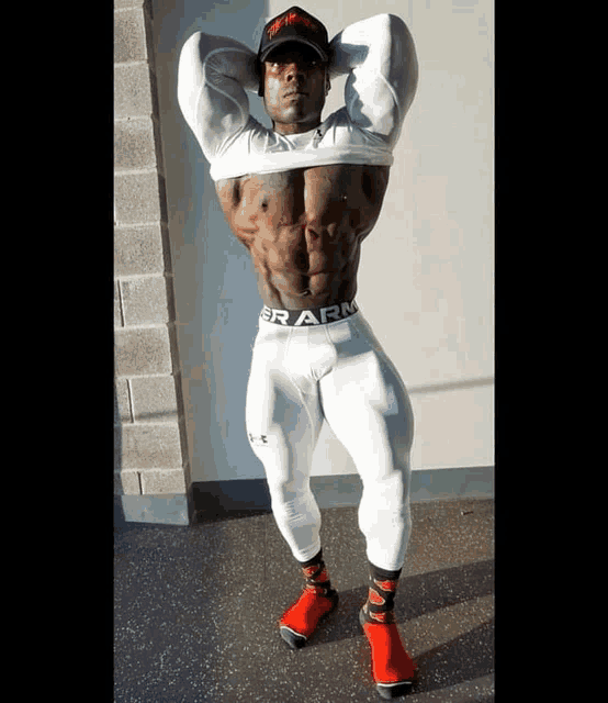 a muscular man wearing under armour tight pants and red shoes