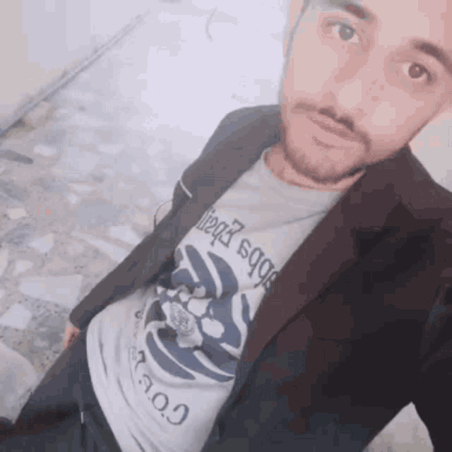 a man with a beard is wearing a t-shirt that says ' aoo ' on the front