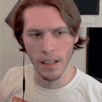 a man wearing headphones is looking at the camera .