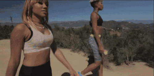 a woman in a sports bra and shorts walks with another woman