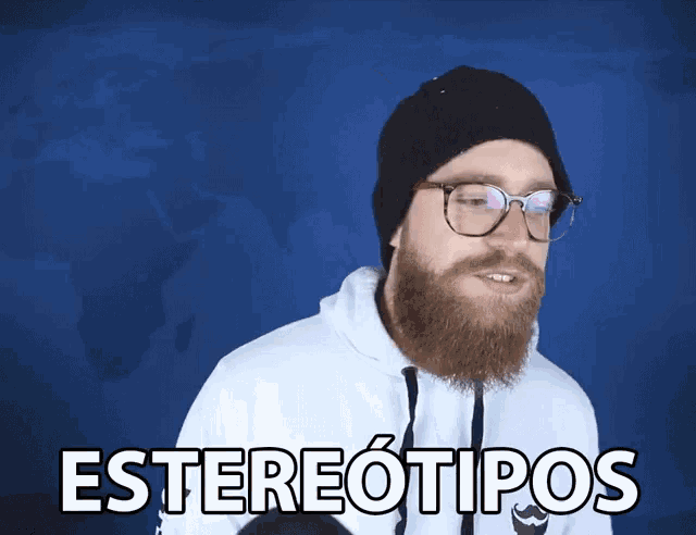 a man with a beard wearing glasses and a white hoodie says estereotipos