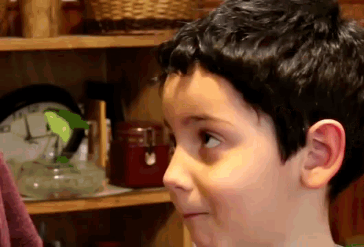 a close up of a boy 's face with a clock in the background and a red box that says ' a '