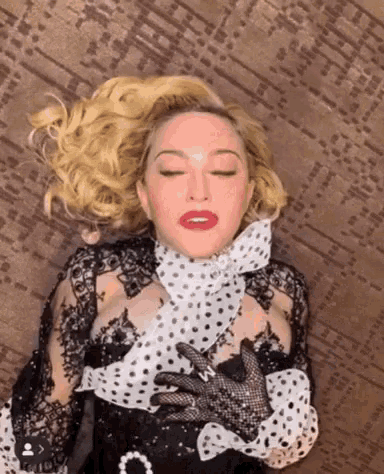 a woman in a black and white polka dot dress is laying down