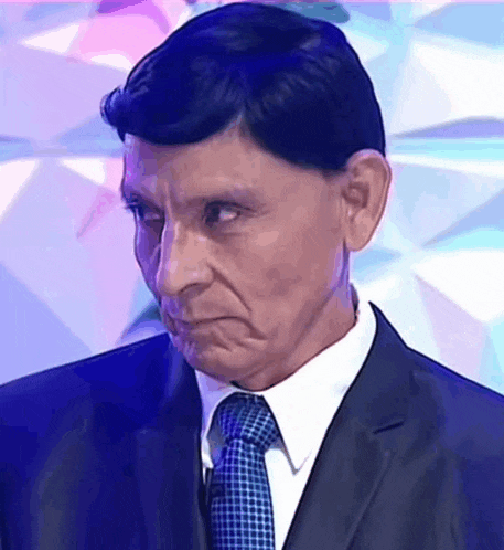 a man wearing a suit and tie is making a funny face .