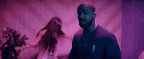 a man and a woman are dancing in a room with purple walls .