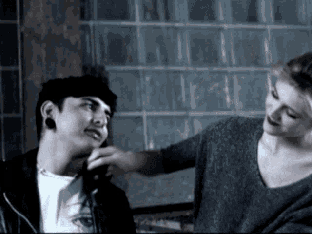 a woman is putting a knife to a man 's neck