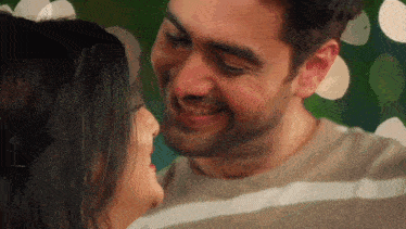 a man and woman are kissing and smiling at each other .
