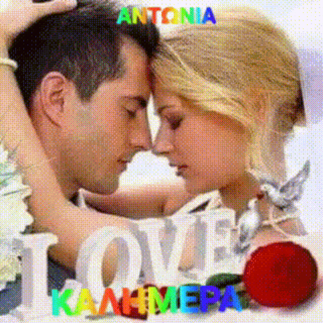 a man and woman are kissing in front of a sign that says " love "