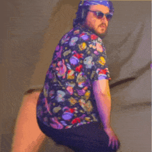 a man wearing a colorful shirt and sunglasses is squatting