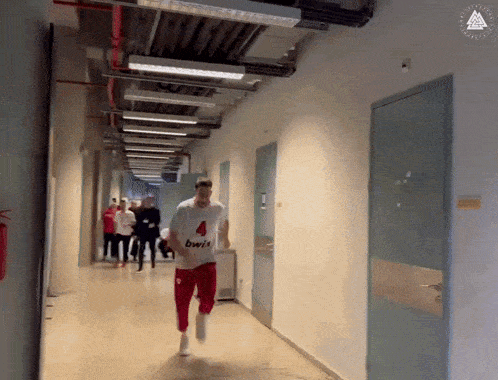 a man running down a hallway with the number 4 on his shirt