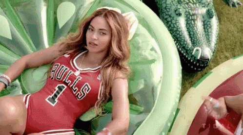a woman in a bulls jersey is laying on a green raft