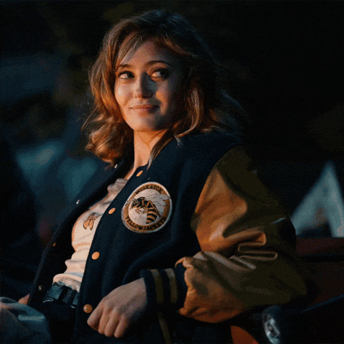 a woman wearing a varsity jacket with a patch that says tigers