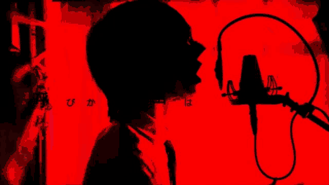 a silhouette of a person singing into a microphone with chinese writing in the background