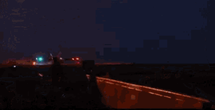 a fighter jet is taking off from a runway at night with a sunset in the background