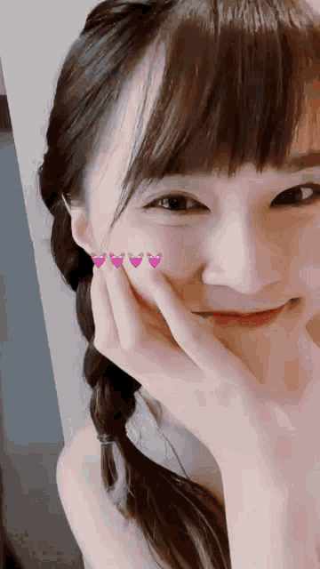a close up of a girl 's face with hearts on her cheeks