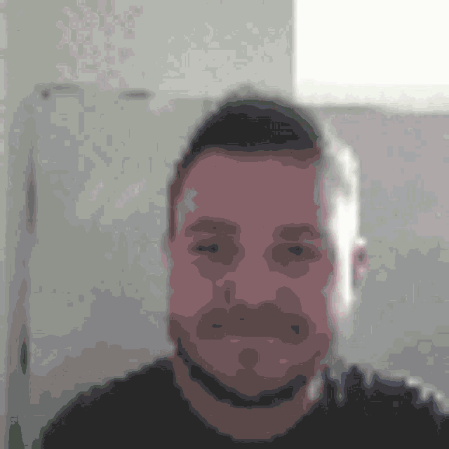 a blurry picture of a man 's face with a beard