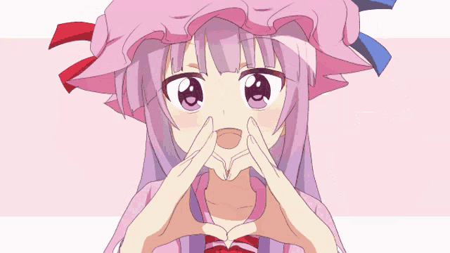 a girl in a pink hat covering her eyes with her hand