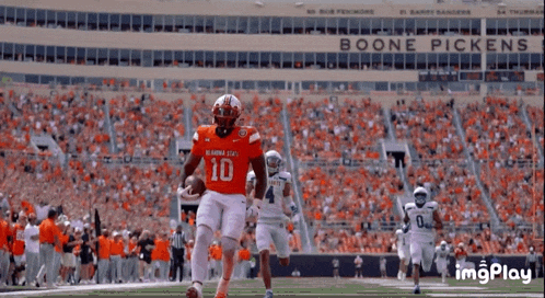 a football player wearing a number 10 jersey is running with the ball