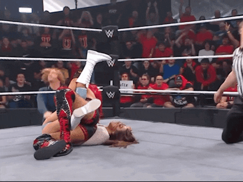 a woman in a wrestling ring with the letter w on the corner