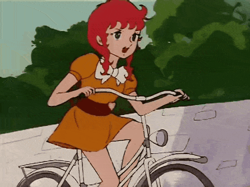 a girl with red hair is riding a bike on a sidewalk