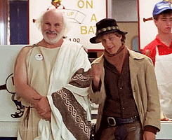 two men shake hands in front of a sign that says " on a bat "