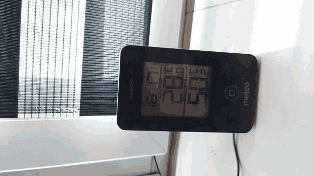 a meteo thermometer is hanging on a window