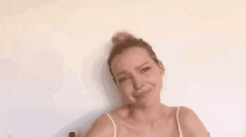 a woman with a bun on her head is holding a bottle of essential oil .