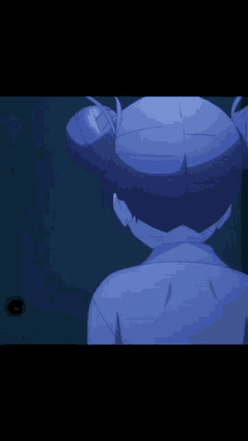 a close up of a girl 's face in a dark room with a blue background .