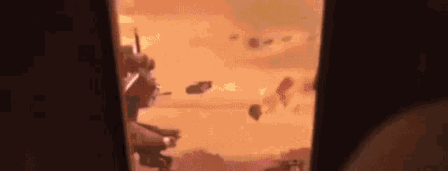 a person is standing in a dark room looking out a window at a cartoon character flying through the air .